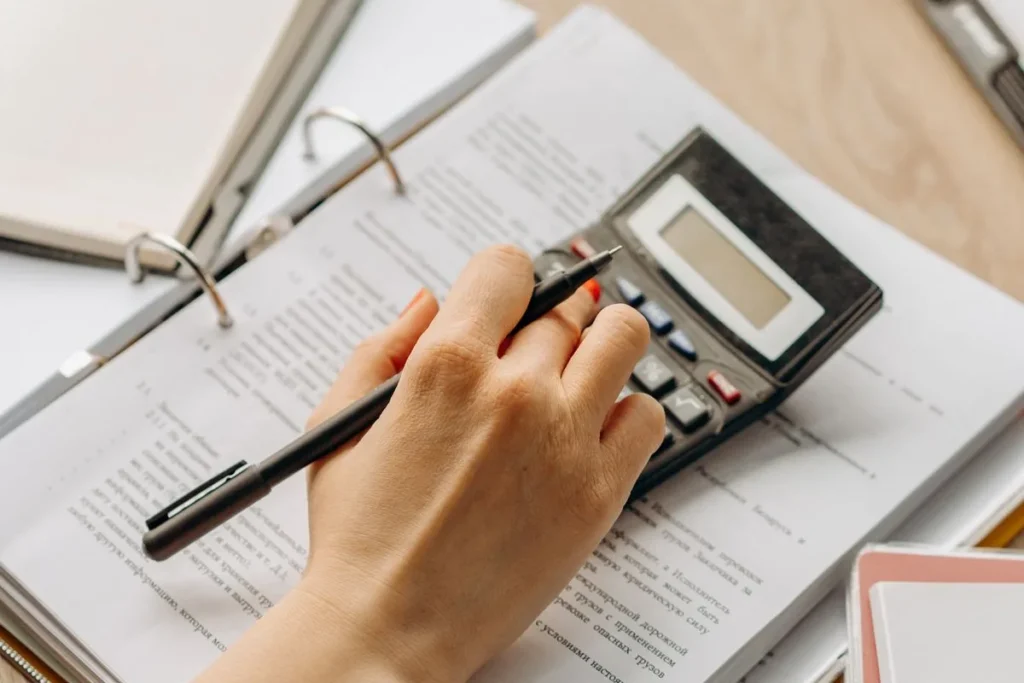 Mano usando una calculadora sobre documentos