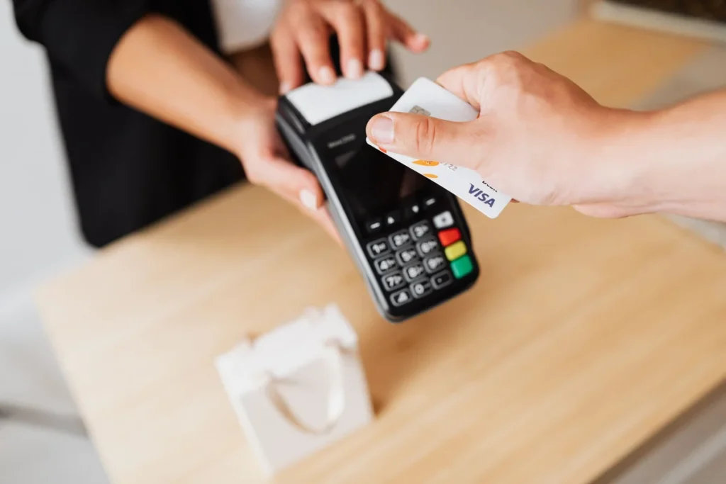 Mano pagando con tarjeta en un terminal de pago